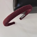 Detail shot of burgundy knitted headband featuring a handmade label and soft wool texture - Burgundy