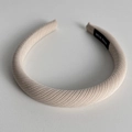 Close-up of beige twill fabric padded headband with a hand-made textile label inside - Beige