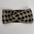 Detail of knitted houndstooth pattern headband with black and gold crossover knot - Coffee