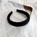 Dettaglio del cerchietto in tweed nero fatto a mano con texture lucida e scritte dorate - Nero