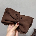 Close-up of dark brown ribbed knit headband featuring a twisted bow knot detail - Dark Coffee