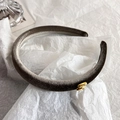 Detalle de diadema de terciopelo gris oscuro con emblema de metal dorado letra M - Estilo Letra M / Caqui