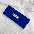 Dettaglio della fascia in maglia blu Klein con un'etichetta tessuta FASHION bianca - Blu scuro
