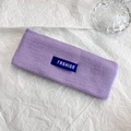 Dettaglio della fascia lavorata a maglia viola con etichetta fashion su carta bianca - Viola