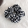 Detalle de coletero de terciopelo a cuadros con pliegues suaves y elegante patrón damero - Negro+Blanco