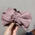 Detail of knitted bow headband showing rose pink ribbed texture and fine edge stitching - Pink