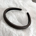Macro detail of deep brown leather headband with fine grain texture and non-slip lining - Brown