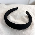 Detail of a thick black fabric headband with a premium woven texture and padded design - Black