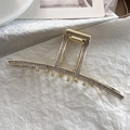 Dettaglio macro della raffinata pinza per capelli dorata con strass bianchi brillanti - Stile Geometrico Quadrato