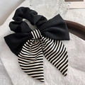 Detailweergave van de zwart-wit gestreepte oversized strik scrunchie met satijnlook - Zwart en Wit Gestreept