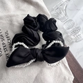 Dettaglio di elastico nero in raso con fiocco grande e finiture di perle bianche - Nero