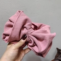 Pink oversized knitted bow headband featuring a ribbed texture and elastic wide design - Pink