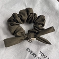 Detailed macro shot of olive green plaid bow hair tie with sparkling rhinestone decor - Dark Green