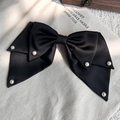 Detail einer eleganten schwarzen Satin-Schleifen-Haarspange mit Perlen auf Canvas-Hintergrund - Bestickter 3-lagiger Schleifenstil