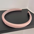 Primer plano de una diadema acolchada rosa loto hecha a mano con tejido de satén - Rosa