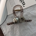 Dettaglio della molletta per capelli a fiore con perla grigia e strass lucidi - Grigio