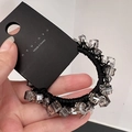 Dettaglio dell'elastico per capelli con perle di cristallo e corda nera intrecciata a mano - Grigio