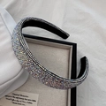 Detalle de una diadema ancha de lujo con brillantes pedrería AB sobre una bandeja decorativa - Colorido