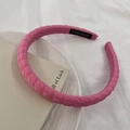 Détail d'un serre-tête en tissu rose matelassé avec étiquette faite main et texture - Rouge Rose