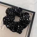 Macro-detail van zwarte satijnen scrunchie met glanzende strassteentjes op linnen dienblad - Zwart
