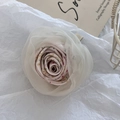 Detailweergave van de roze stoffen bloem haarklem met lagen van doorschijnend organza - Eendenbek Clip
