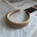 Detail of handmade champagne satin padded headband with high-gloss finish on tissue paper - Khaki