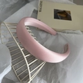 Detailansicht des zartrosa Satin-Schwammstirnbands mit eleganter glänzender Textur - Rosa