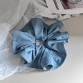 Detailed macro view of soft blue fabric scrunchie texture and fine stitching detail - Blue