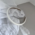Detalle de una diadema acolchada blanca con textura de cuero sintético y forro interior antideslizante - Blanco