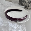 Dettaglio del cerchietto in vernice viola scuro con fiocco in metallo argento sul vassoio - Borgogna