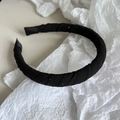 Dettaglio di un cerchietto in tessuto nero con glitter e punte in nastro morbido - Nero