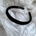 Detailed close-up of a handmade black velvet headband with a professional woven label - Black