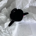 Primer plano de la pinza para el pelo de felpa negra sobre papel blanco texturizado - Negro