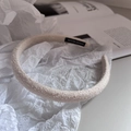 Detailed macro view of beige tweed fabric headband featuring a handmade fabric label - Beige