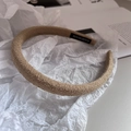 Detail of light khaki knit fabric headband with handmade label on white paper background - Khaki