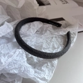 Detail of dark grey fabric headband with hand made label on soft white background - Gray