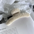 Detailed view of large cream beige fluffy hair claw clip on lifestyle background - Apricot