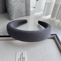 Close-up of thick grey knitted wool headband featuring premium textured fabric and sponge padding - Gray