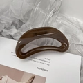 Primo piano di un grande fermaglio per capelli a mezzaluna ambra su sfondo minimalista - Lucido / Cachi