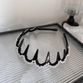 Dettaglio di un cerchietto punk nero con punte e perle bianche artificiali eleganti - Nero Con Perla Bianca