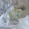Detail showing plumeria hair claw clip with blue and yellow splattered paint pattern - Yellow And Blue