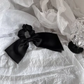 Elegante coletero con lazo de satén negro sobre un fondo blanco con textura - Lazo de una Sola Capa