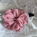 Macro shot of oversized dusty rose chiffon scrunchie with soft pleated texture - Pink