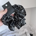Detailansicht eines schwarzen Blumen-Scrunchie mit weißem Print und Designer-Etikett - Schlanke Taille Stil