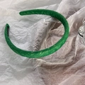Détail d'un serre-tête en dentelle verte avec étiquette fait main sur fond de papier blanc - Vert