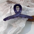 Détail d'une pince à cheveux violet foncé effet gelée avec ressort métallique sur bois - Violet