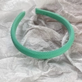 Dettaglio ravvicinato del cerchietto in tessuto a costine verde menta con cuciture - Verde fresco