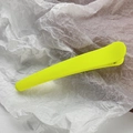 Macro shot of a neon yellow matte hair clip on a textured white background paper - Neon Yellow