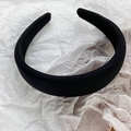 Close-up of thick black padded headband with satin finish on white textured paper - Black