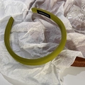 Detail showing grass green fabric headband with a handmade label on a white background - Matcha Green